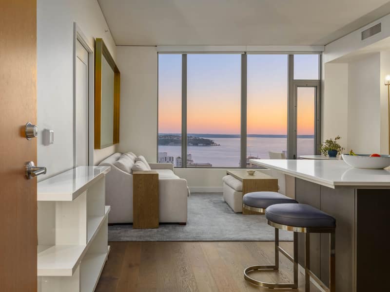 Entry opening to the living room with a city and water view at dusk