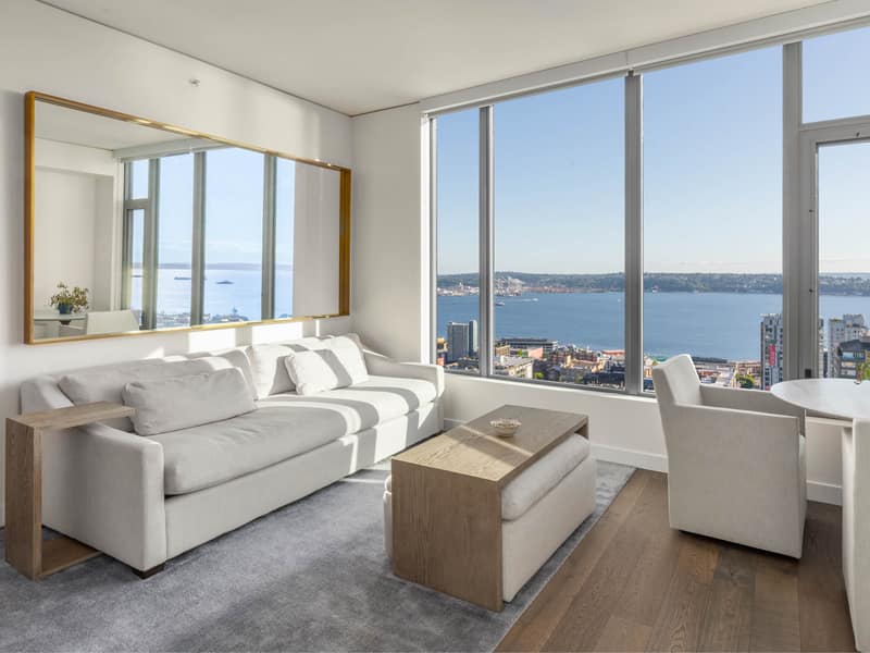 Staged living room with Elliott Bay reflected in a large wall mirror