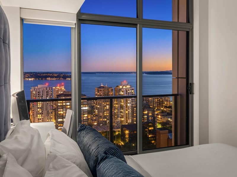 Primary bedroom with city lights at night